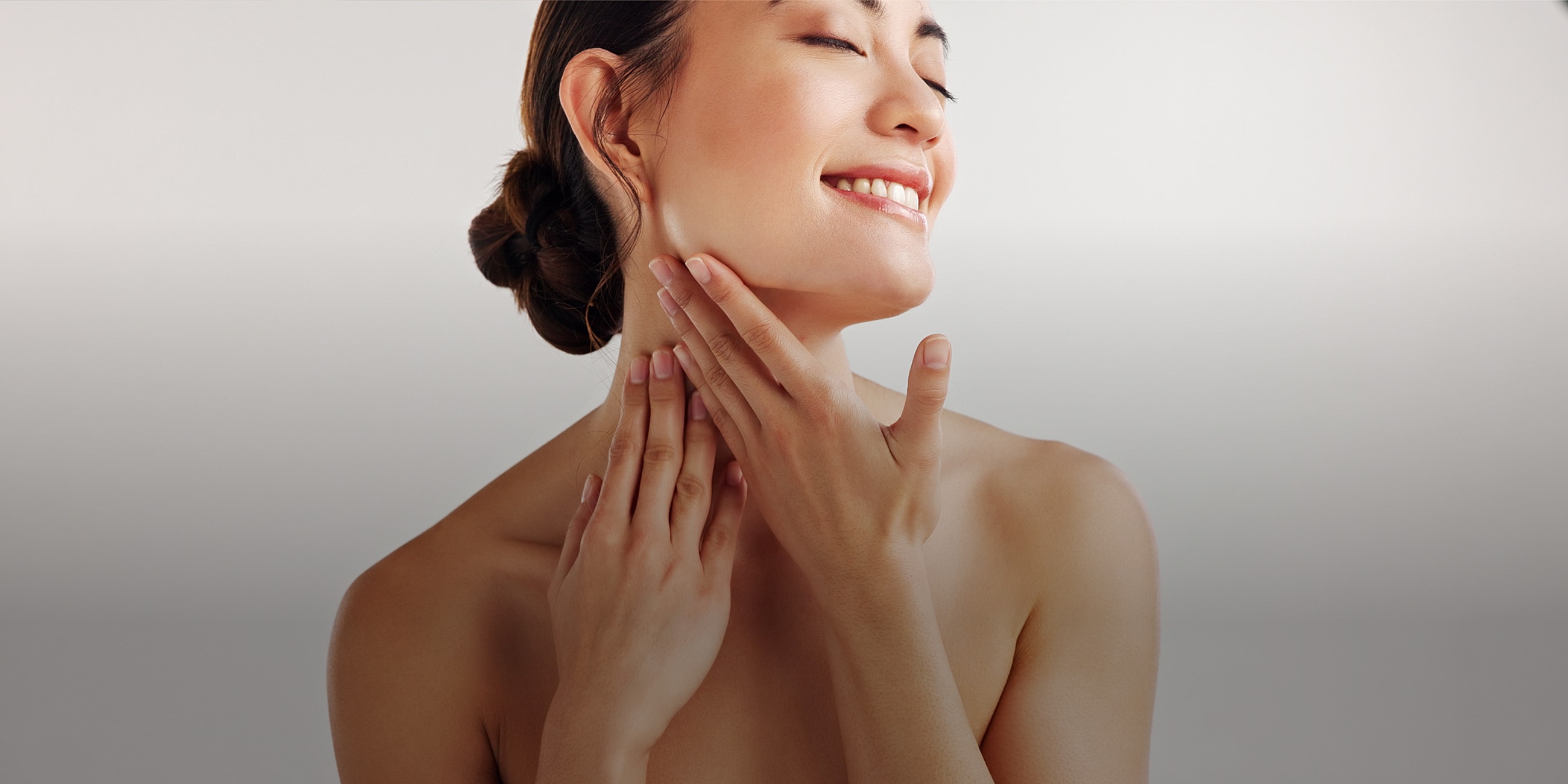 Woman enjoying skincare routine, smiling gently.
