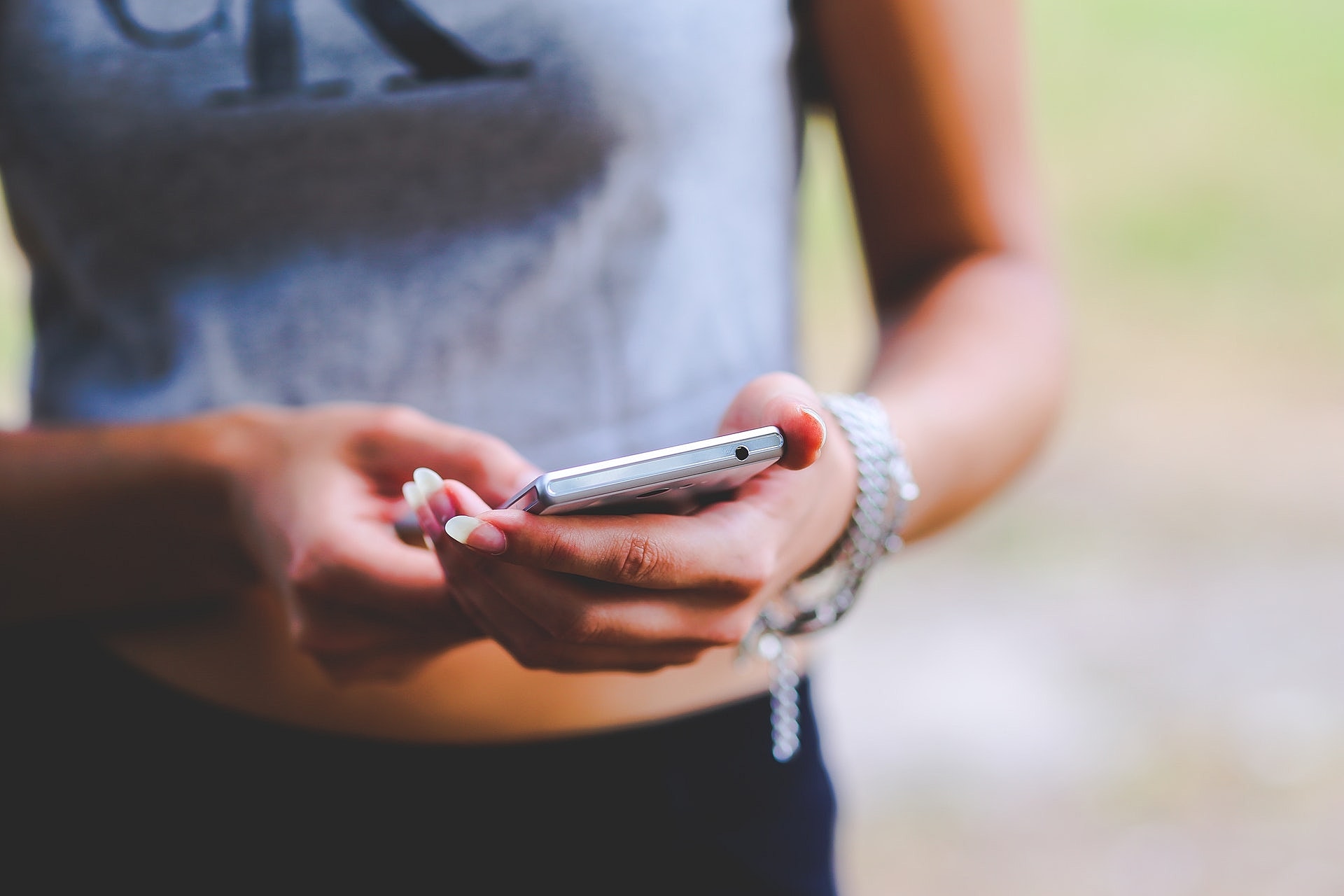 Person holding a smartphone outdoors.