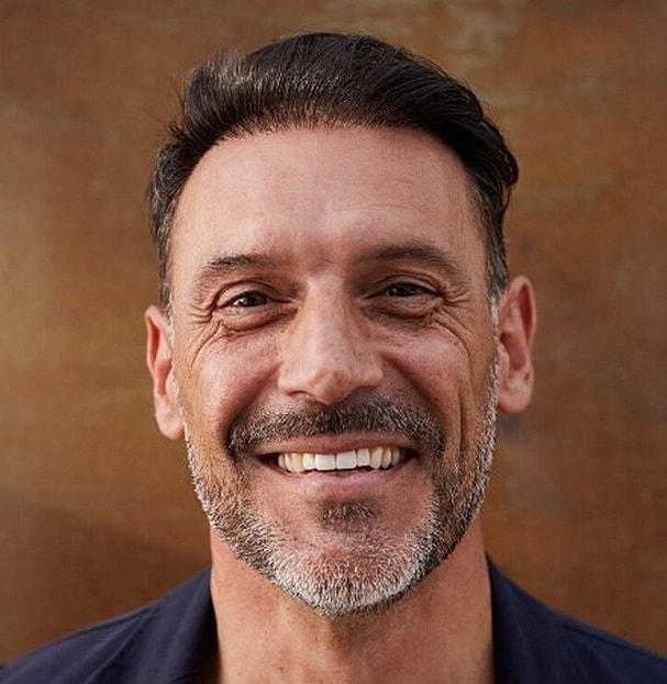 Smiling man with short dark hair and beard.