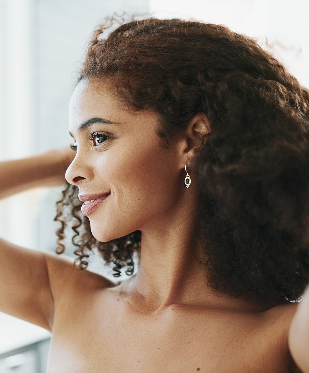 Woman with curly hair and elegant earrings.