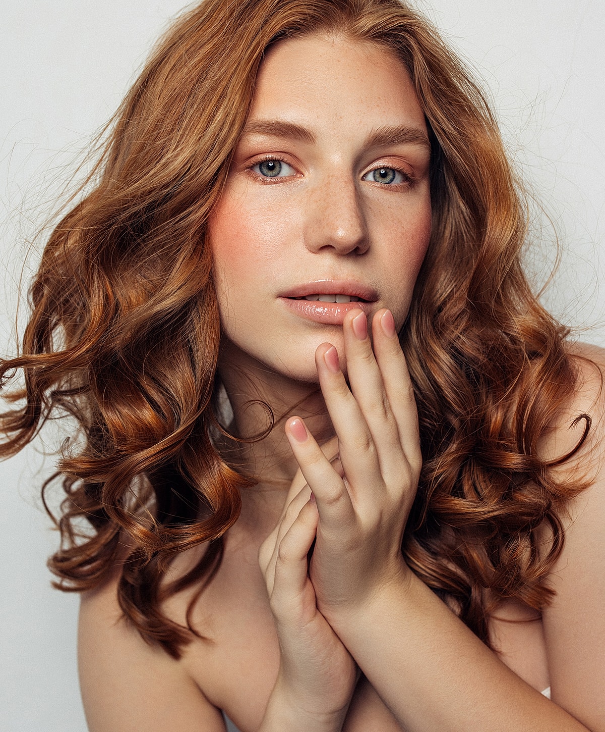 Red-haired woman with soft curls and natural beauty.