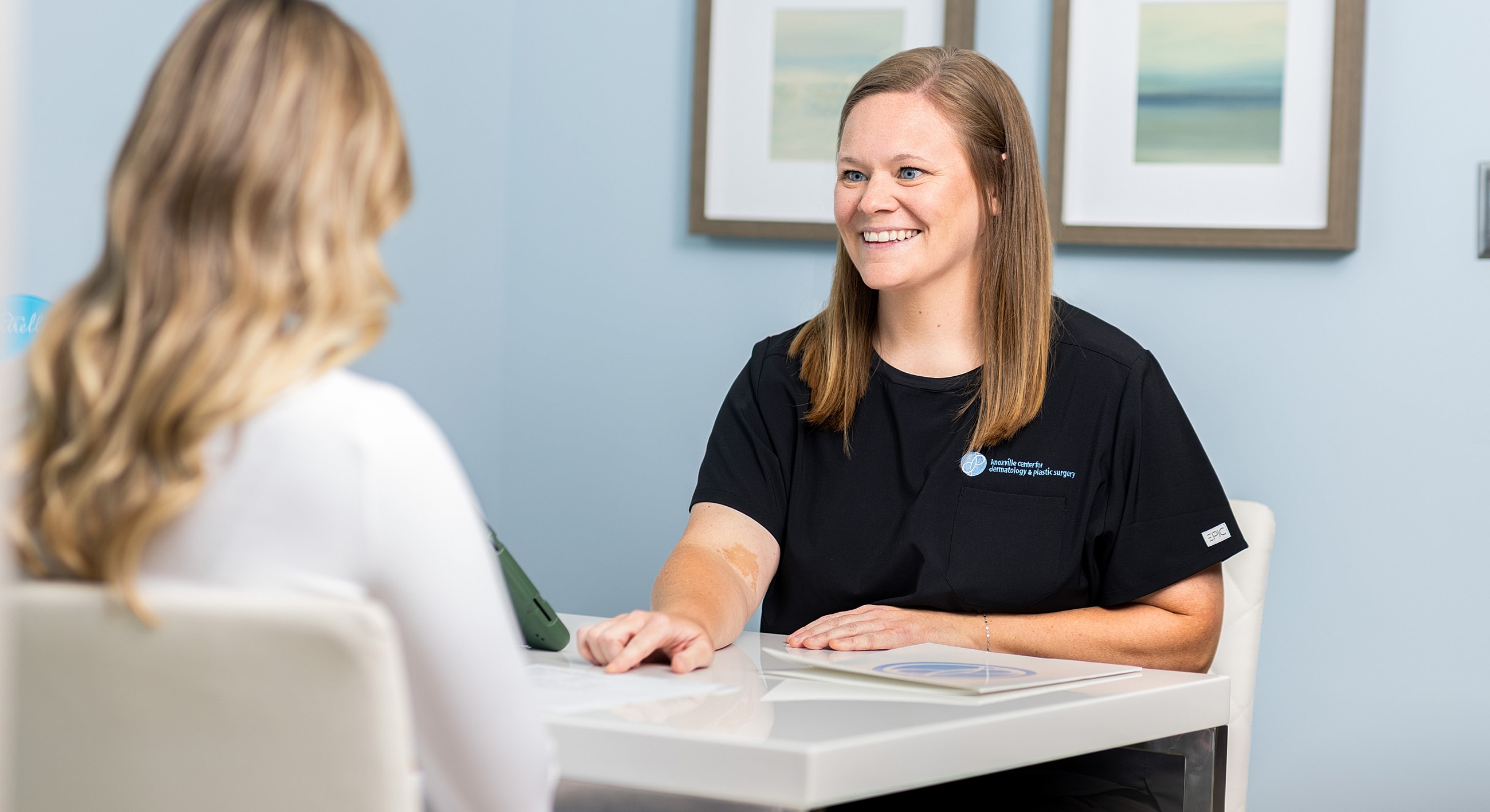 Consultation between two women in a medical setting.