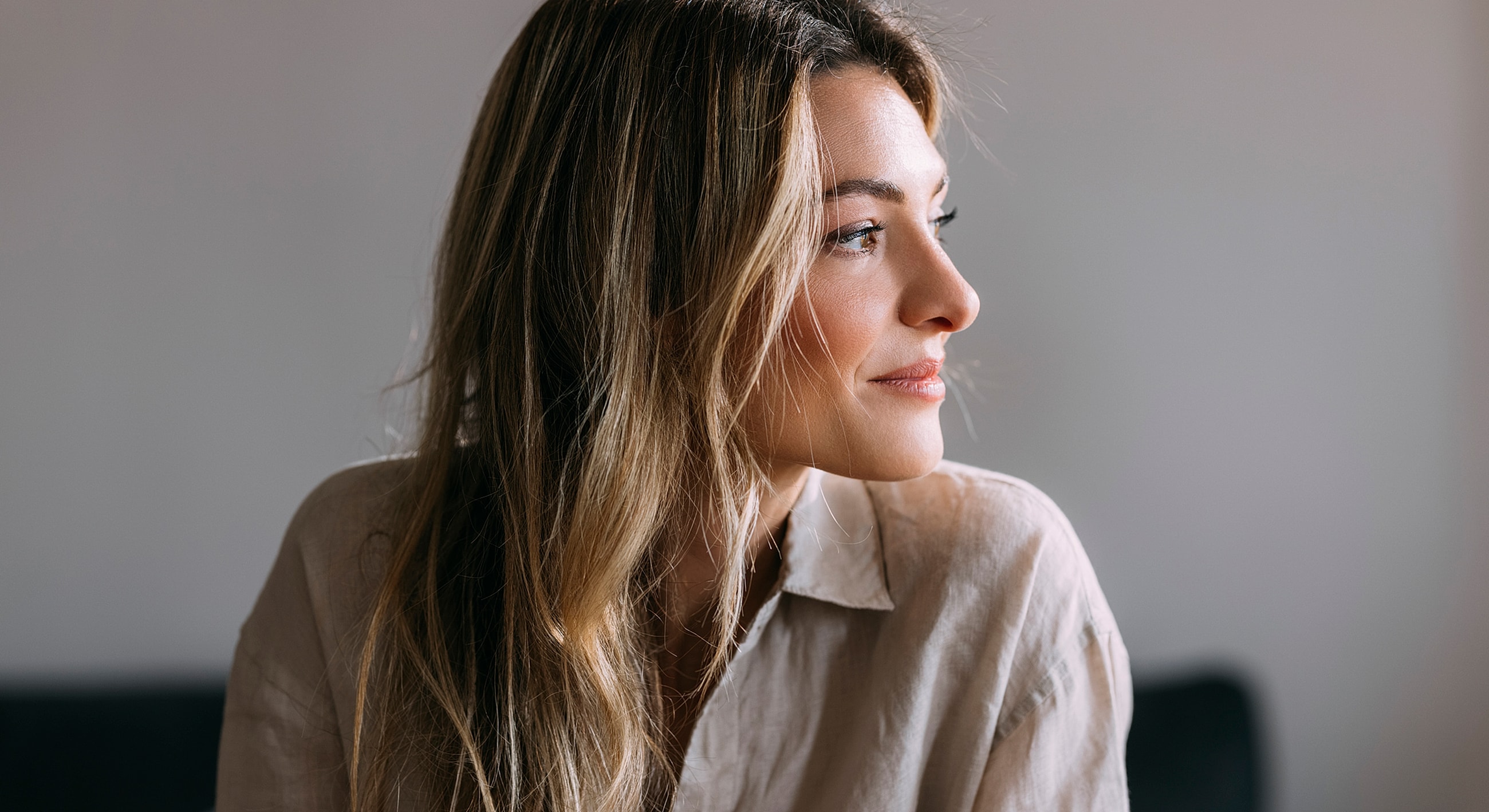 Profile of a woman with long, wavy hair.
