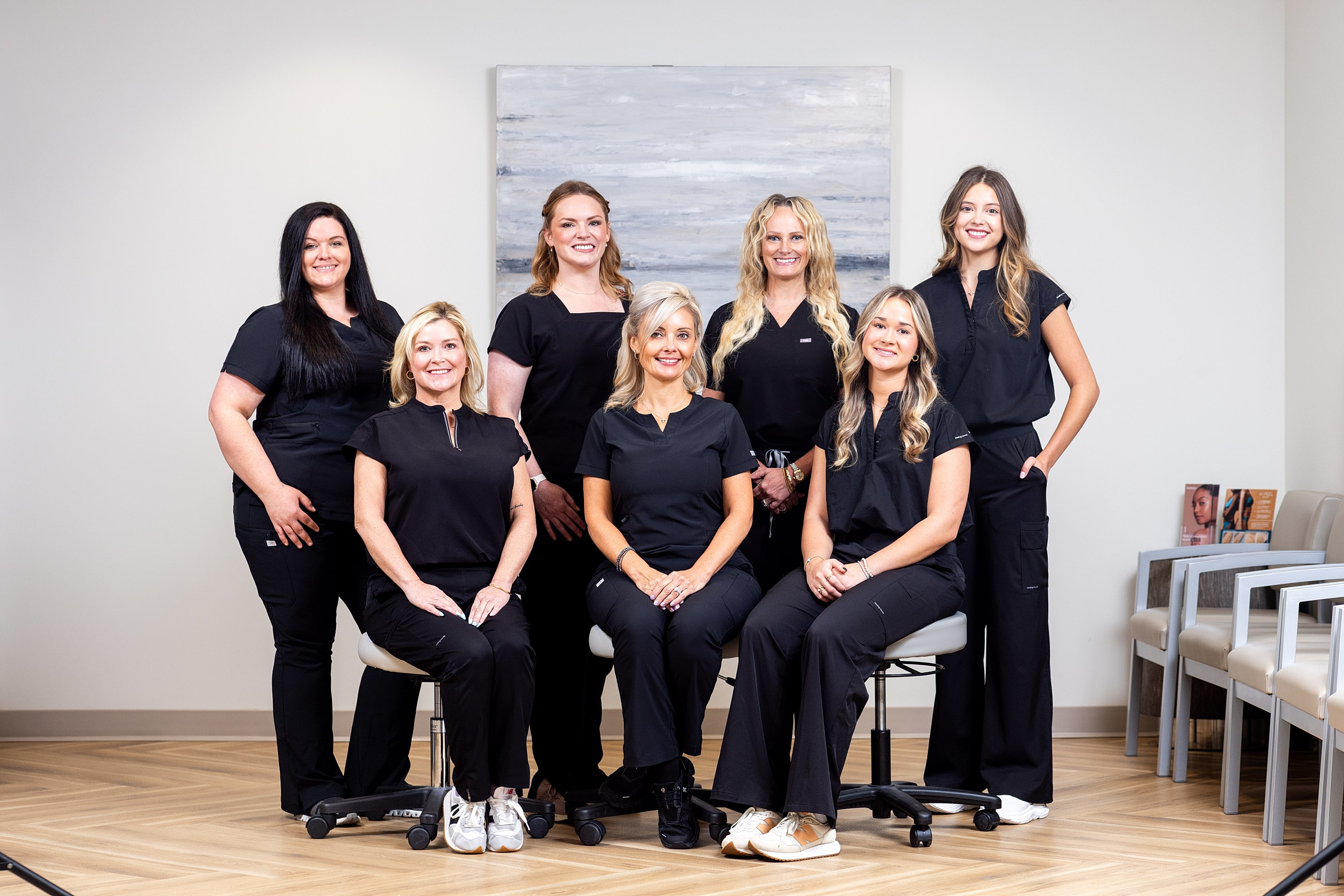 Medical team posing in modern office setting.