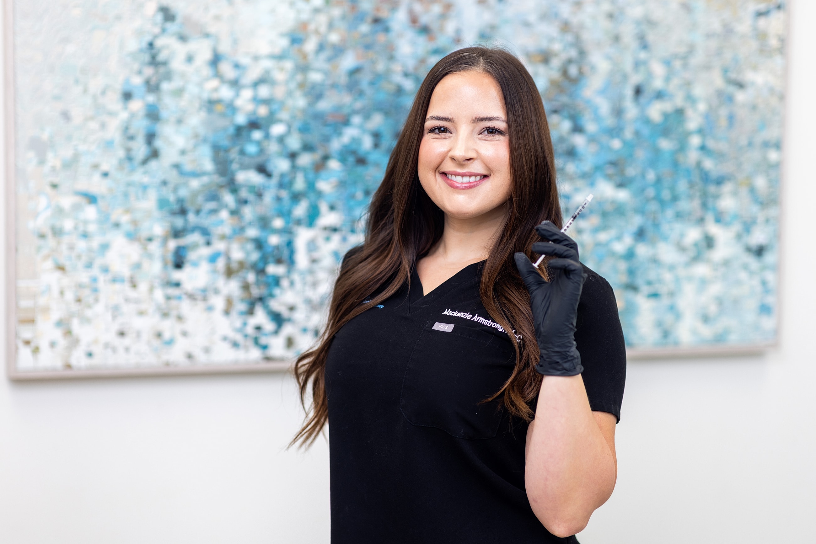 Healthcare professional holding a syringe, smiling.