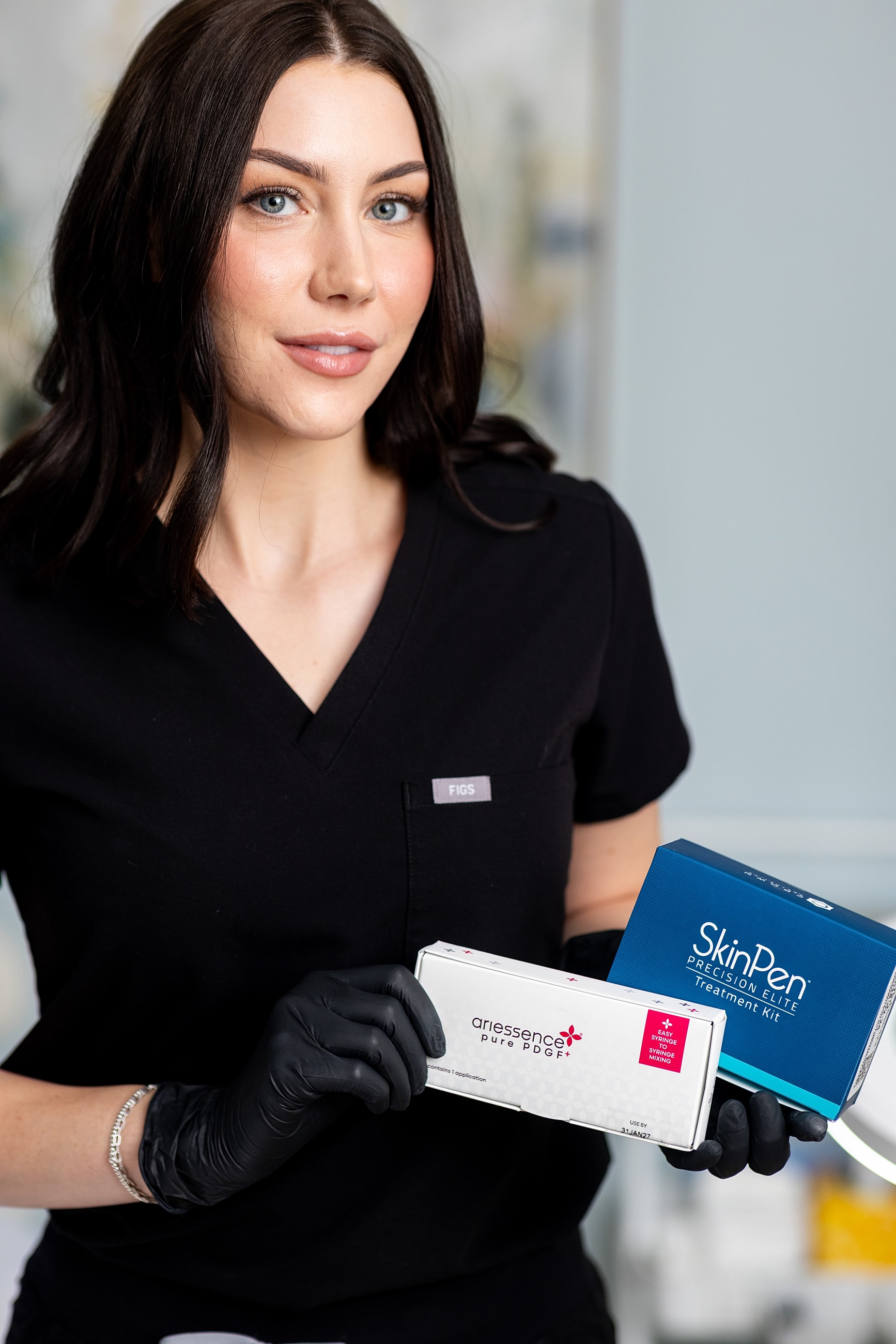 Skincare professional holding treatment products in clinic.
