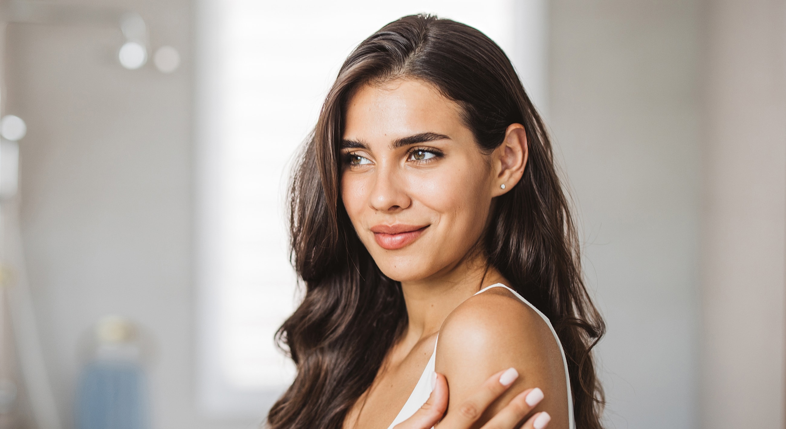 Smiling woman with long hair and natural makeup.